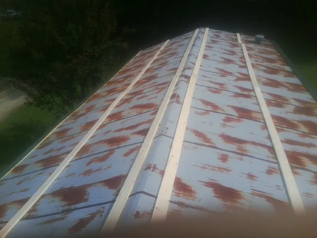 Rusted metal roof panels with new wood purlins before replacement — Storm Damage Roof Repair in Ehrhardt by Roofing Brothers