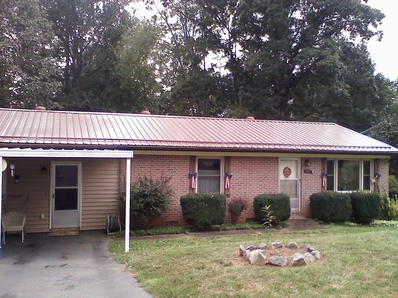 Bronze metal roof and carport on a brick ranch home — Roof Repair work by our crew in Ehrhardt
